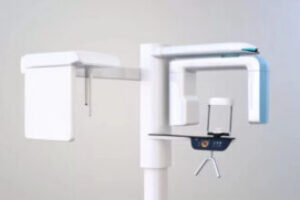 Close-up of panoramic dental X-ray machine with chin rest and rotating arm, used for imaging teeth and jaw in clinic.